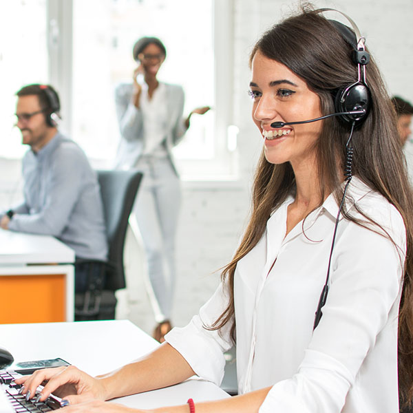 An IT support technician with a telephony headset on discussing Microsoft 365 with a client.